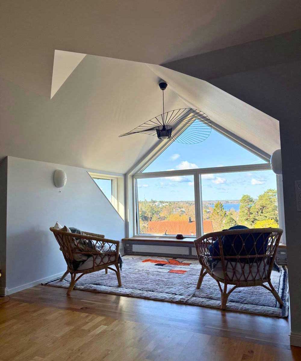 En glad byggarbetare som står på ett tak.